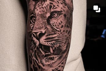 Tatuagem realista de felino no braço feita em estúdio de tatuagem no RJ